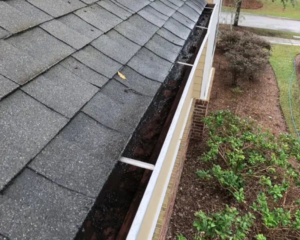 A gutter that is leaking water from the roof.